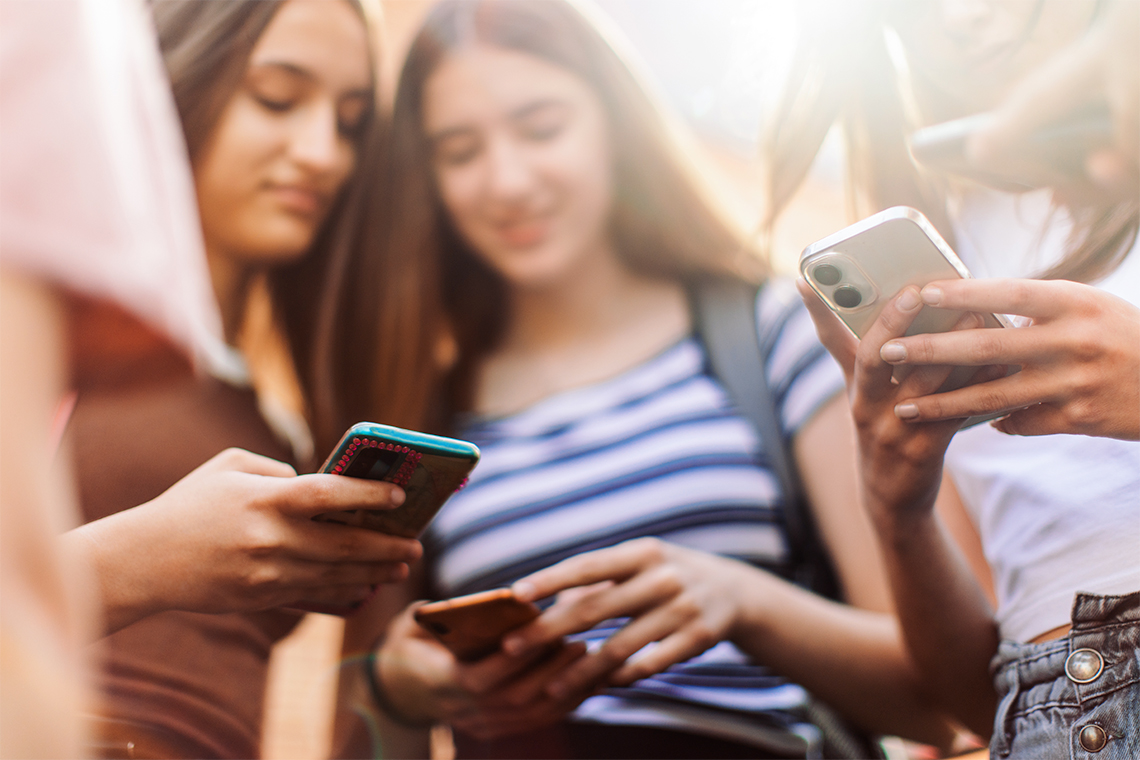 Group of teenagers using their smartphones.