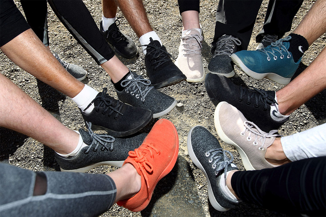 A group of people wearing shoes putting one foot in to form a circle