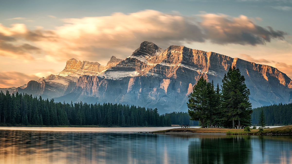 Early autumn morning on the lake shore. Wonderful sun and clouds over Mount Rundle