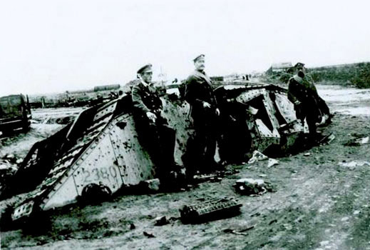 Soldiers smoking cigarettes and leaning on a tank that is half in the ground, clearly broken down