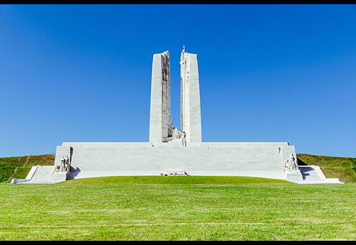 Large, geometric,smooth stone structure as a memorial for the Battle at Vimy Ridge surrounded by well-kept grass