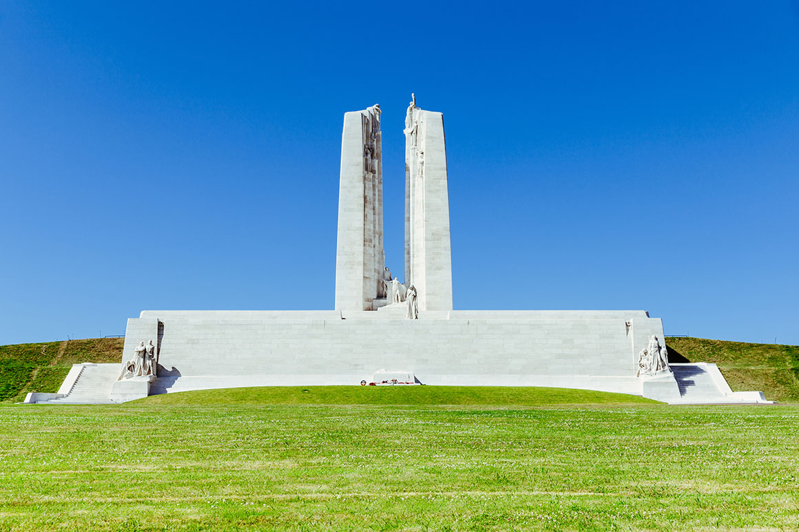 Large, geometric,smooth stone structure as a memorial for the Battle at Vimy Ridge surrounded by well-kept grass