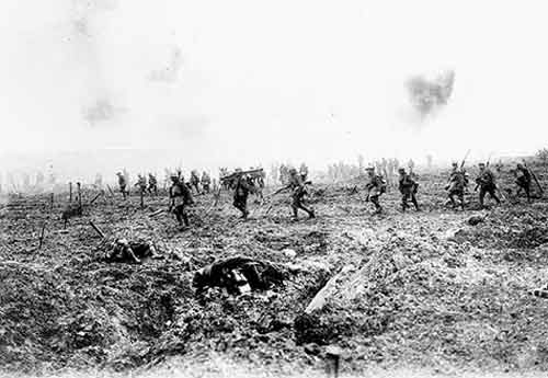 Canadian soldiers walking through the field of war as they gain territory on their enemy