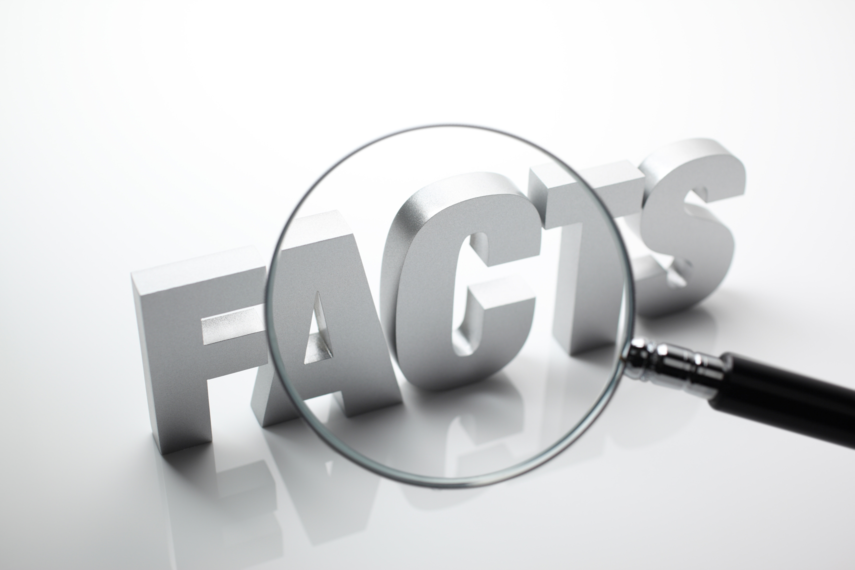 The word “fact” magnified by a magnifying glass