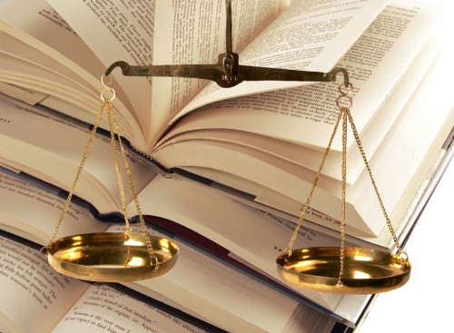 Evenly weighted scales in front of a set of books