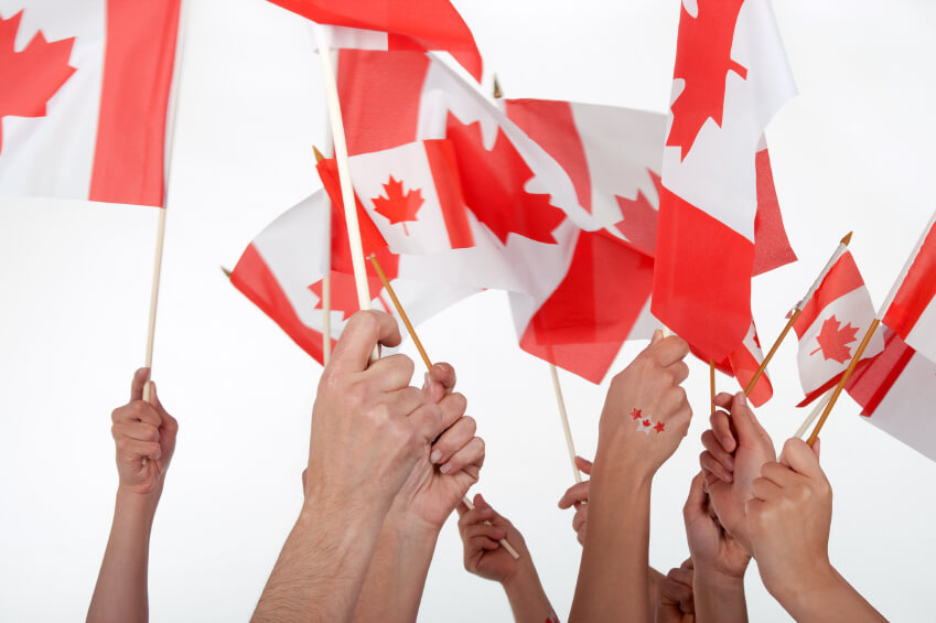 image of hands holding up Canadian flags