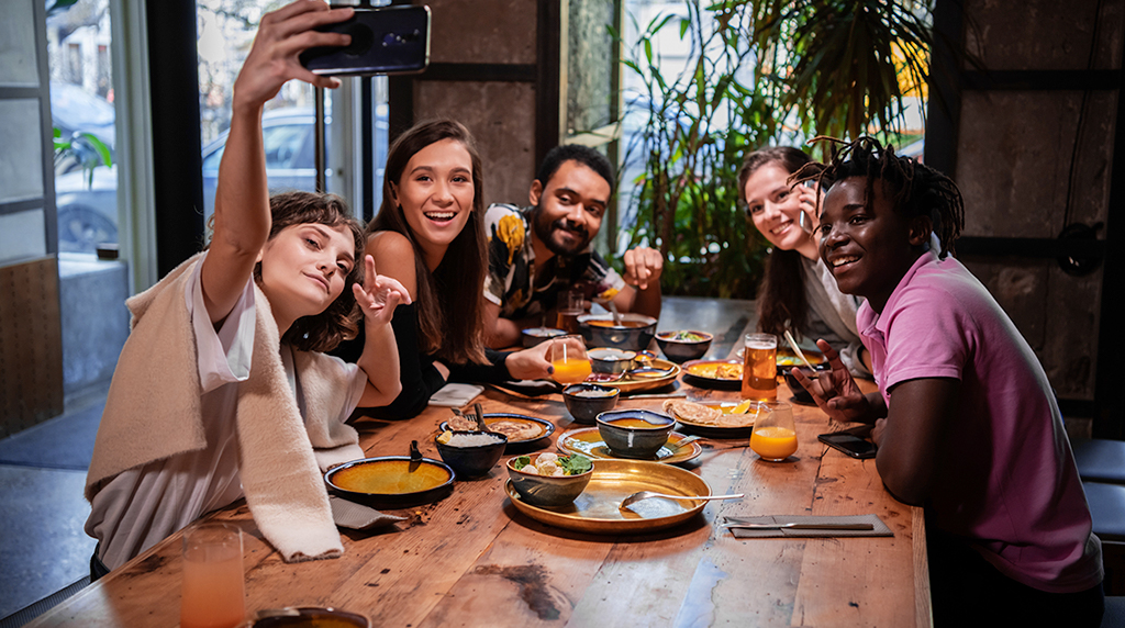 Friends taking pictures of themselves at a dinner party