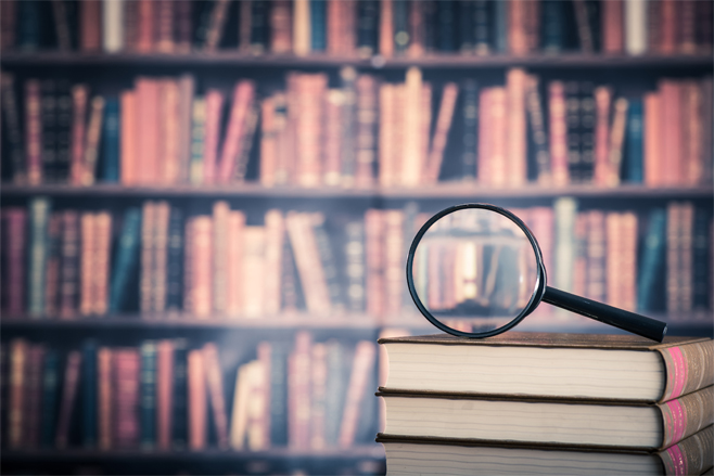 A series of books on shelves and a magnifying glass