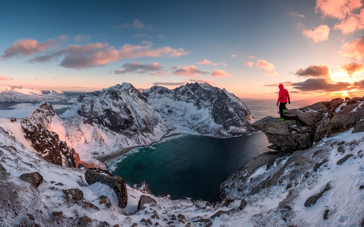 personne faisant une randonnée dans les montagnes enneigées au coucher du soleil