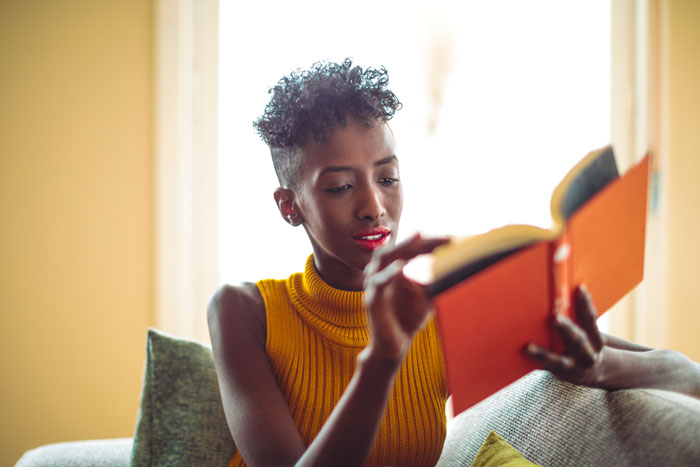  Une personne qui lit un livre sur un canapé