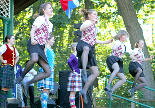 Young women in traditional Scottish clothes dancing a jig 