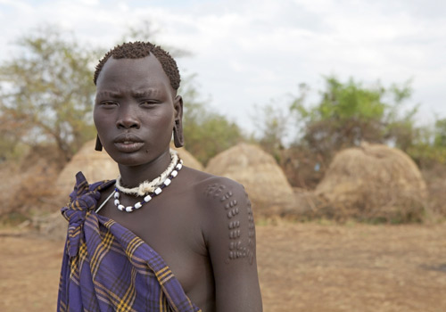 African woman of the Mursi ethnic group showing her traditional scarification