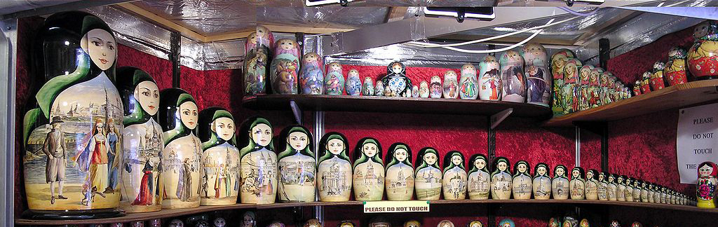 Thirty Russian nesting dolls side-by-side on a shelf