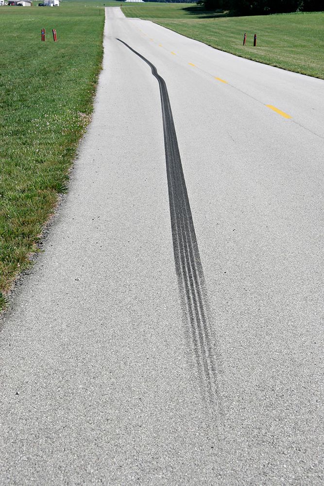 Photo of long skid mark on a paved road.