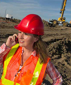 Young woman wearing a safety vest and hard hat on a construction site Young woman wearing a safety vest and hard hat on a construction site