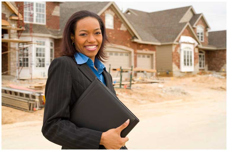 Woman holding folder in front of houses being built