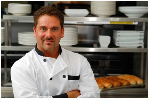 Man standing in kitchen with chef's uniform on