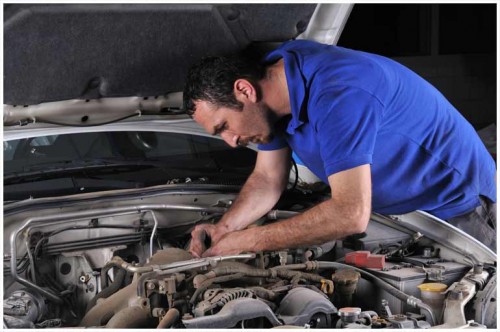 Man working in hood of a car
