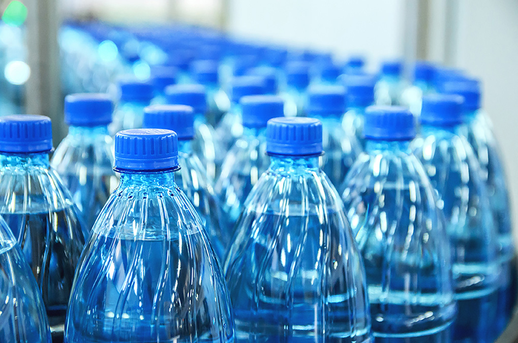 Gros plan sur des bouteilles en plastique d’eau minérale dans une chaîne de production.