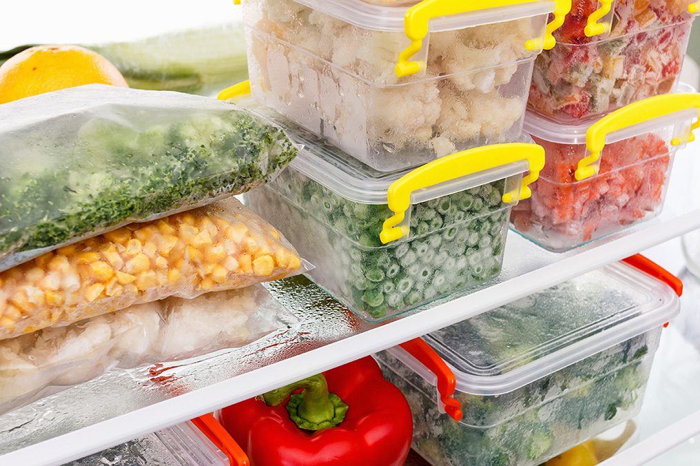 Frozen food in plastic bags and containers in the refrigerator.
