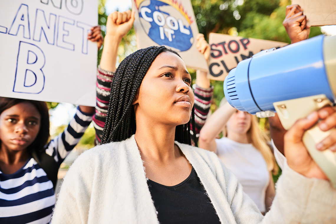 A person holds a megaphone at a climate protest
