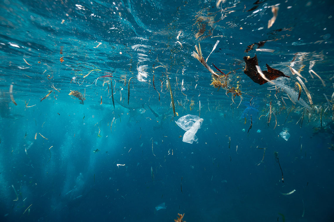 Underwater perspective of plastic garbage and other contaminants in a body of water.