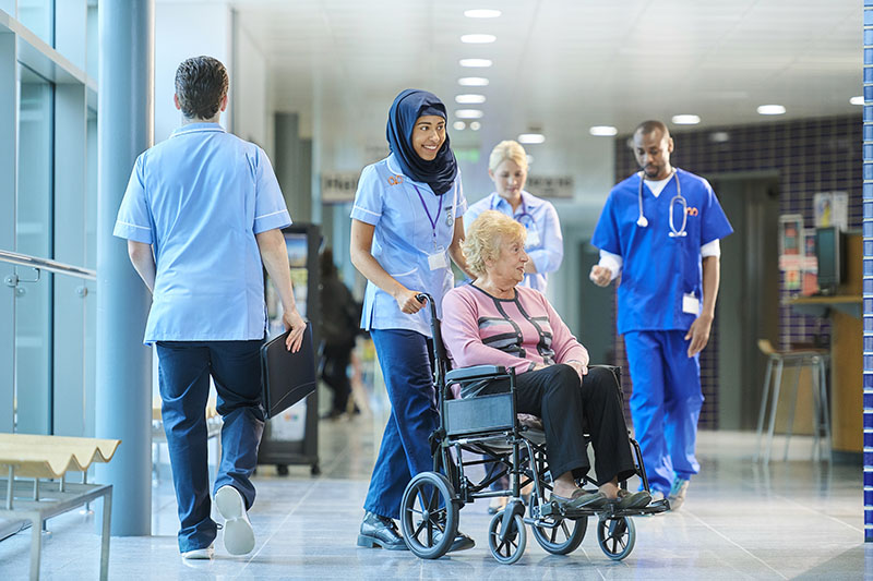 nurse escorts a senior patient