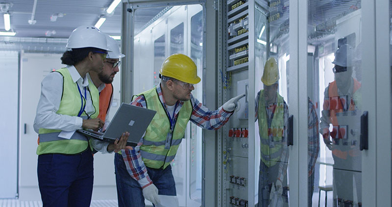 engineers with papers working in control center