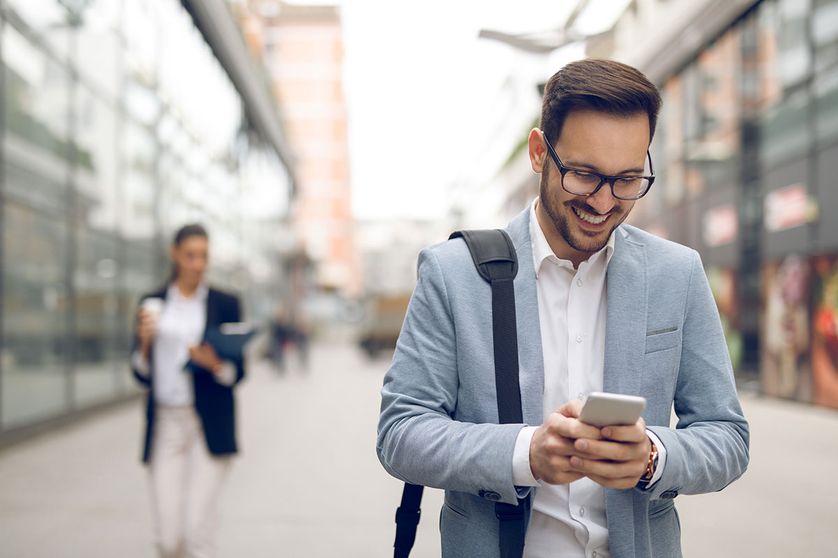 Young businessman typing text message on his way to work