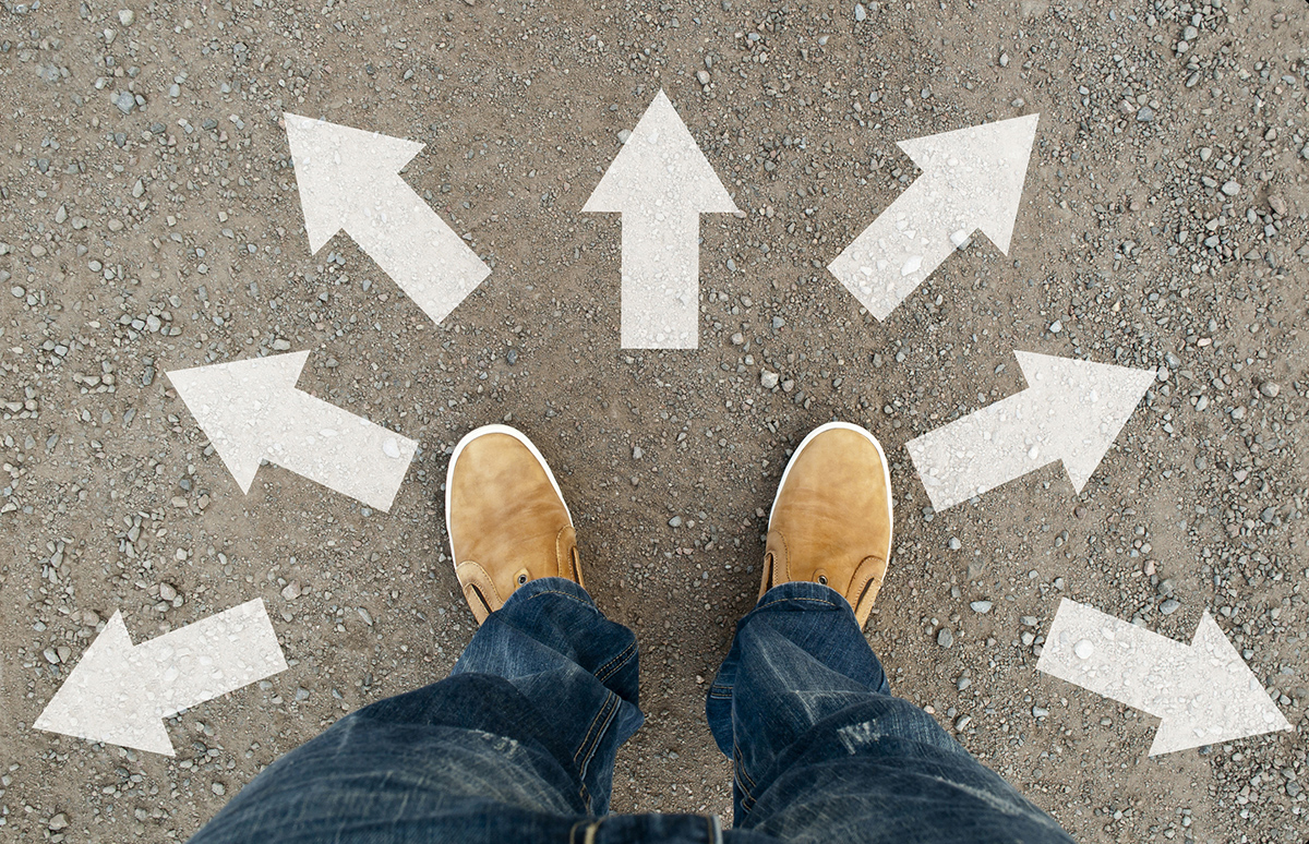 An individual standing with multiple different arrows pointing in different directions.