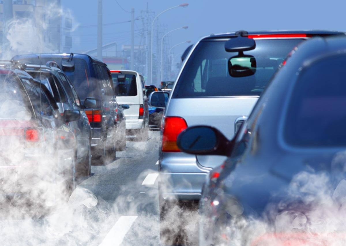 Busy highway with excessive smoke leaving vehicle exhaust pipes.