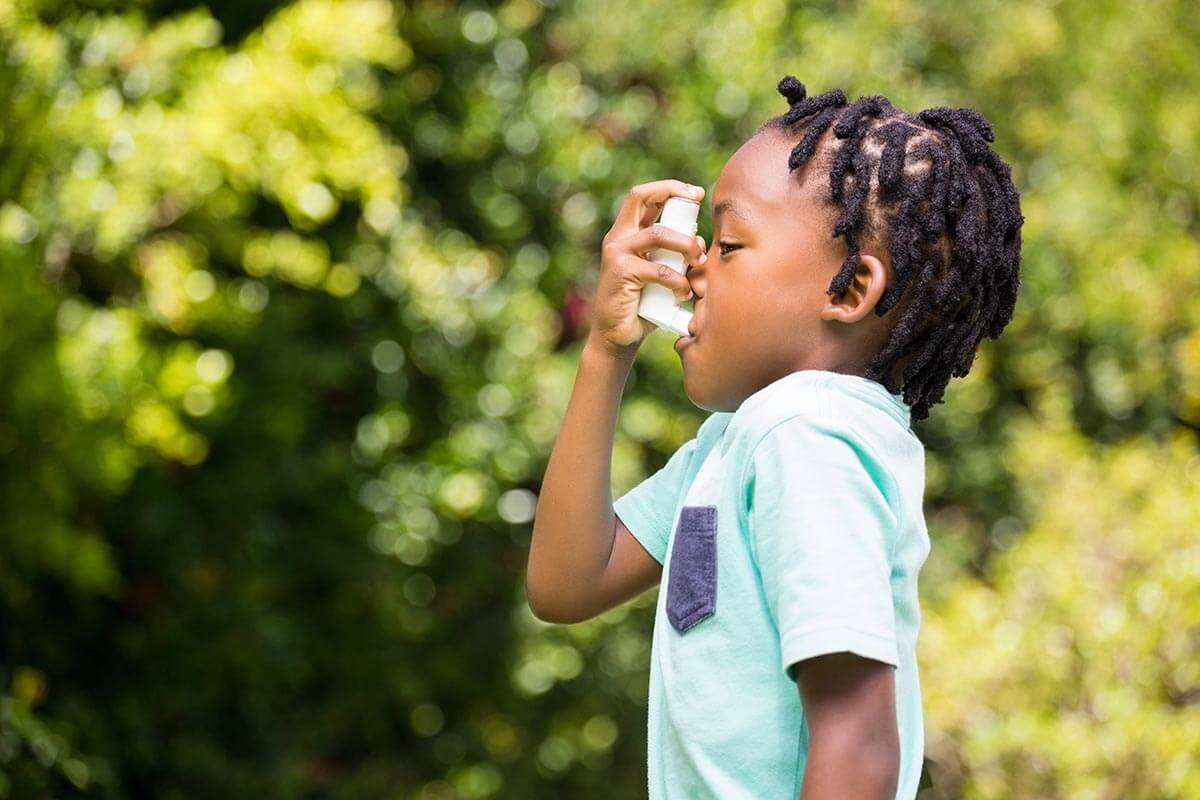 Small child using an asthma inhaler.