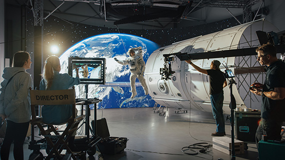 The set of a sci-fi movie with a director, camera and sound people.