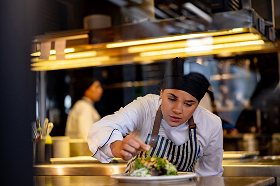 A chef plating food at a restaurant.