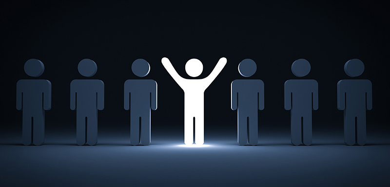 Stick figure with hands up in spotlight with other stick figures with hands beside their bodies in shadow beside him