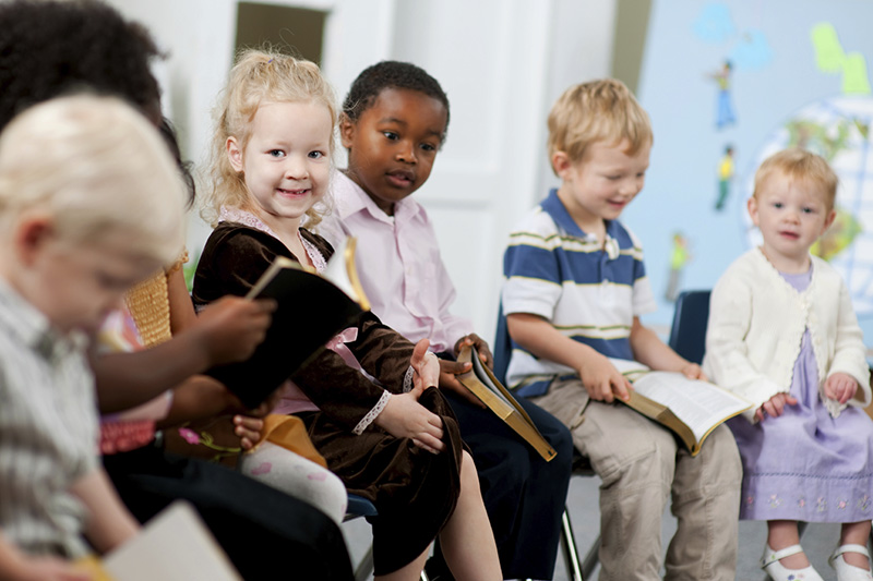 Children holding holy books in religious study